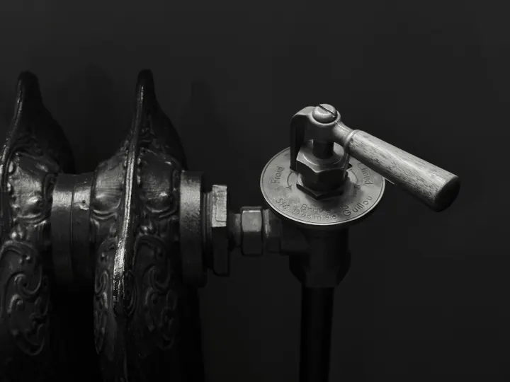 A vintage cast iron radiator with an ornate metal valve handle