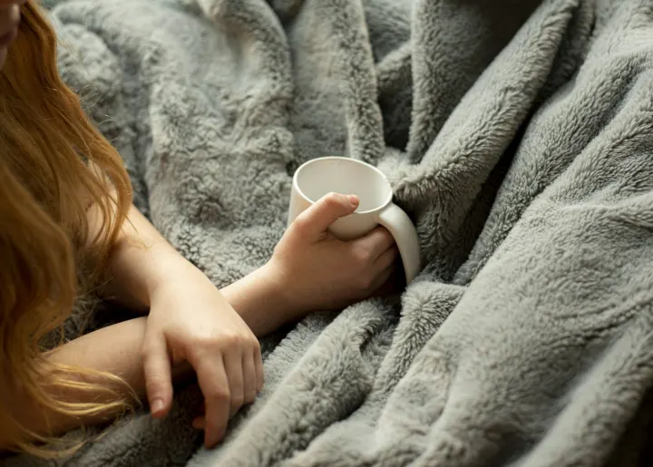 Woman holding white ceramic mug